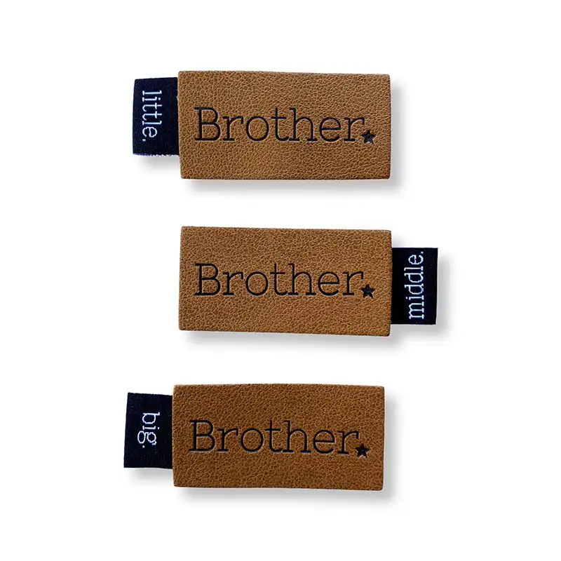 3 Lederlabels mit Aufschrift Brother seitlich ein Weblabel mit Aufschrift