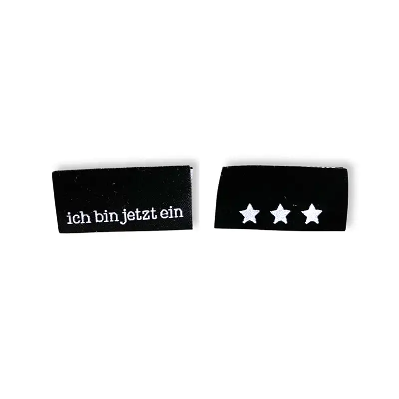 schwarzes Weblabel mit dem Aufdruck ich bin jetzt. schwarzes Weblablel mit 3 Sternen